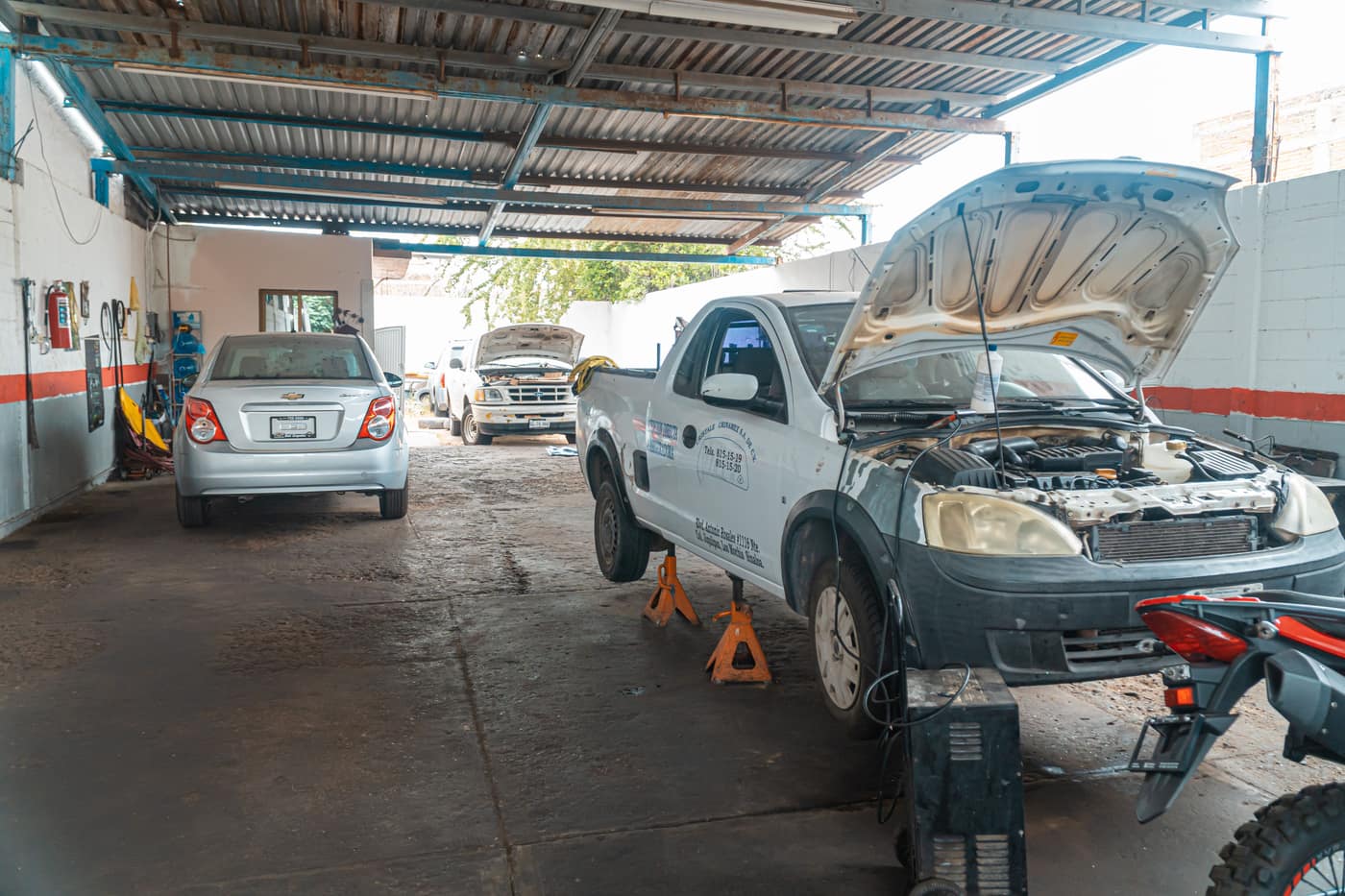 Interior de un taller mecánico con autos en reparación